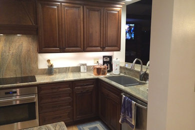 Trendy kitchen photo in Tampa with stainless steel appliances, stone slab backsplash and granite countertops