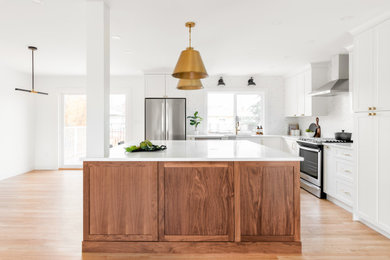 Open concept kitchen - mid-sized 1950s l-shaped light wood floor and beige floor open concept kitchen idea in Vancouver with an undermount sink, shaker cabinets, dark wood cabinets, quartz countertops, white backsplash, ceramic backsplash, stainless steel appliances, an island and white countertops