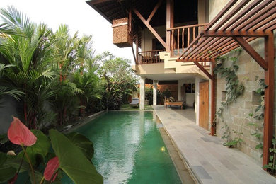 Example of a mid-sized island style beige one-story stone house exterior design in Other