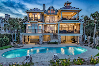 Example of a large classic backyard brick and custom-shaped lap hot tub design in Other