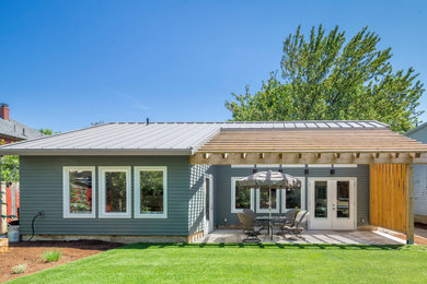 Diseño de fachada de casa azul y gris moderna pequeña de una planta con revestimiento de aglomerado de cemento, tejado a dos aguas y tejado de metal
