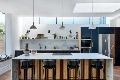 This is an example of a large scandinavian single-wall kitchen/diner in London with a submerged sink, flat-panel cabinets, black cabinets, quartz worktops, white splashback, engineered quartz splashback, integrated appliances, dark hardwood flooring, an island, brown floors and white worktops.