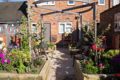 Ejemplo de jardín tradicional en patio con macetero elevado