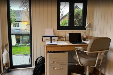 Photo of a small contemporary study in Hampshire with beige walls, laminate floors and brown floors.