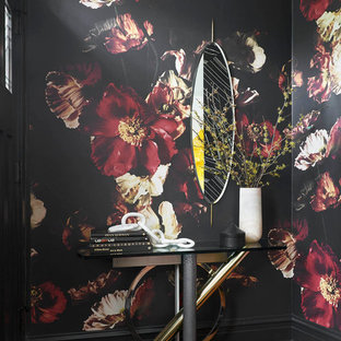 Inspiration for a mid-sized eclectic foyer in Chicago with black walls, medium hardwood floors and a black front door.
