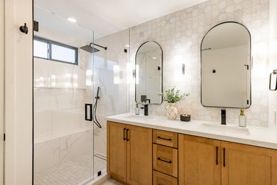 Inspiration for a large contemporary master white tile and marble tile ceramic tile, beige floor, double-sink, coffered ceiling and brick wall bathroom remodel in Los Angeles with shaker cabinets, medium tone wood cabinets, a one-piece toilet, white walls, an undermount sink, quartz countertops, white countertops and a built-in vanity