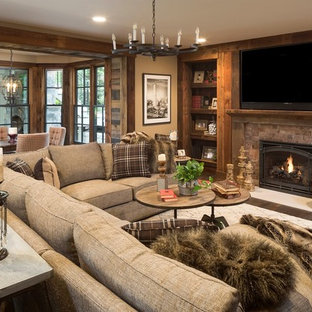 ミネアポリスのトラディショナルスタイルのおしゃれな地下室 (半地下 (窓あり) 、茶色い壁、濃色無垢フローリング、標準型暖炉、レンガの暖炉まわり) の写真