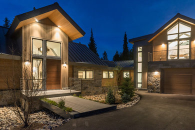 Inspiration for a large contemporary brown three-story wood exterior home remodel in Phoenix with a metal roof