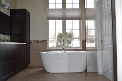 Inspiration for a transitional multicolored tile and porcelain tile bathroom remodel in Detroit with an undermount sink, recessed-panel cabinets, dark wood cabinets and solid surface countertops