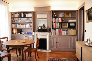 Foto de sala de estar con biblioteca abierta clásica renovada de tamaño medio con paredes beige, suelo de madera clara, todas las chimeneas y televisor independiente
