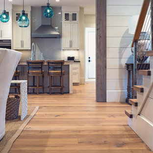 Idéer för lantliga hallar, med vita väggar och mellanmörkt trägolv