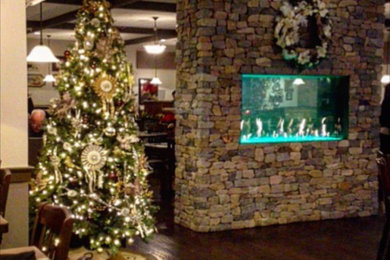 Inspiration for a mid-sized timeless formal and enclosed dark wood floor and brown floor living room remodel in Boston with beige walls, a two-sided fireplace, a stone fireplace and no tv