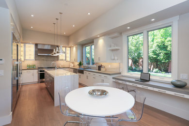Inspiration for a contemporary u-shaped kitchen remodel in San Francisco with a farmhouse sink, white cabinets, stainless steel appliances and an island