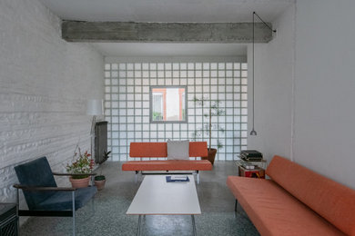 Cette photo montre un salon industriel de taille moyenne avec un mur blanc et un sol gris.