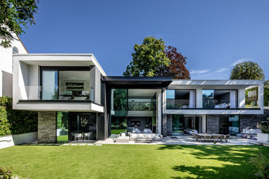 Design ideas for an expansive and white contemporary rear detached house in London with three floors and a white roof.