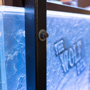 Glass private bar and glass stair treads inside a man cave in Michigan