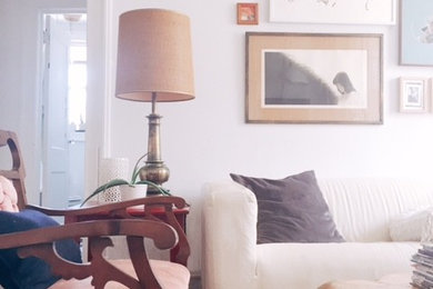 Example of a small eclectic enclosed medium tone wood floor living room design in Richmond with white walls and no fireplace