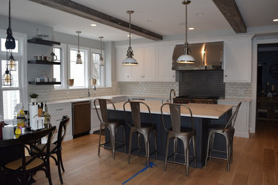 Photo of a transitional kitchen in Chicago with shaker cabinets, white cabinets, quartzite benchtops and with island.