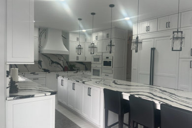 Mid-sized trendy u-shaped eat-in kitchen photo in Philadelphia with flat-panel cabinets, white cabinets, quartzite countertops, white backsplash, white appliances, an island and white countertops
