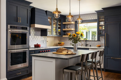Inspiration for a mid-sized transitional l-shaped medium tone wood floor and brown floor enclosed kitchen remodel in New York with an undermount sink, recessed-panel cabinets, blue cabinets, quartzite countertops, metallic backsplash, glass tile backsplash, stainless steel appliances, an island and multicolored countertops