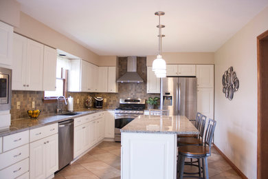 Mid-sized trendy l-shaped porcelain tile enclosed kitchen photo in Other with an undermount sink, raised-panel cabinets, white cabinets, granite countertops, gray backsplash, porcelain backsplash, stainless steel appliances and an island