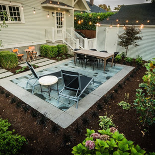 This is an example of a small modern backyard full sun formal garden for summer in Portland with with privacy feature and natural stone pavers.