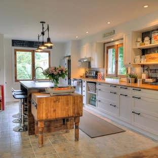 Mid-sized farmhouse kitchen pantry ideas - Example of a mid-sized country single-wall ceramic floor kitchen pantry design in Montreal with shaker cabinets, white cabinets, wood countertops, gray backsplash and an island