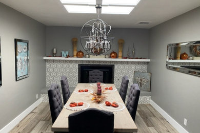 Cette photo montre une salle à manger ouverte sur la cuisine chic de taille moyenne avec un sol en carrelage de céramique et un manteau de cheminée en carrelage.