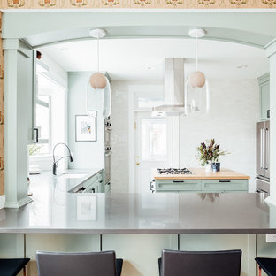 Photo of a mid-sized arts and crafts kitchen in Salt Lake City with an integrated sink, shaker cabinets, green cabinets, solid surface benchtops, stainless steel appliances, cement tiles, with island, grey floor and grey benchtop.