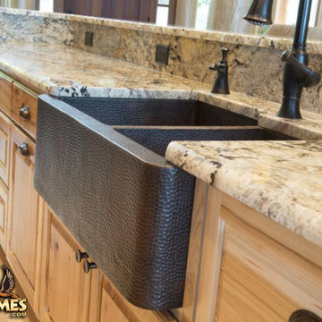 Hammered copper kitchen farm sink in a log home