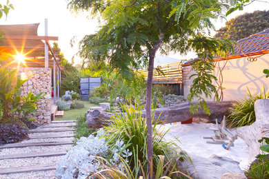 Inspiration for a modern backyard formal garden in Perth with with outdoor playset and natural stone pavers.