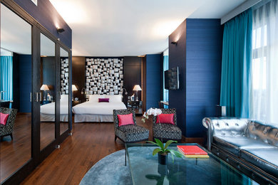 Bedroom - large modern master medium tone wood floor bedroom idea in New York with blue walls