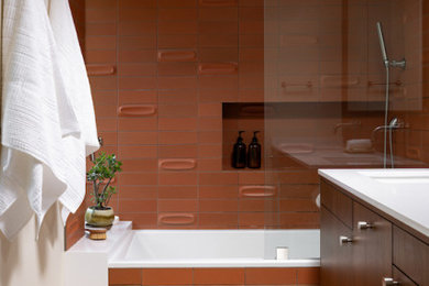 サクラメントにある高級な中くらいなミッドセンチュリースタイルのおしゃれなマスターバスルーム (フラットパネル扉のキャビネット、濃色木目調キャビネット、アルコーブ型浴槽、シャワー付き浴槽	、オレンジのタイル、磁器タイル、ベージュの壁、テラゾーの床、アンダーカウンター洗面器、クオーツストーンの洗面台、マルチカラーの床、オープンシャワー、白い洗面カウンター、ニッチ、洗面台2つ、フローティング洗面台、三角天井) の写真