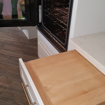Hinged oven with nearby pull-out cutting boards facilitates access and safe tra