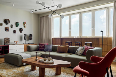 Пример оригинального дизайна: большая гостиная комната в современном стиле с серыми стенами, паркетным полом среднего тона, телевизором на стене и зоной отдыха