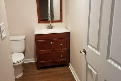 Diseño de cuarto de baño tradicional de tamaño medio con armarios estilo shaker, puertas de armario de madera oscura, sanitario de una pieza y suelo de madera oscura