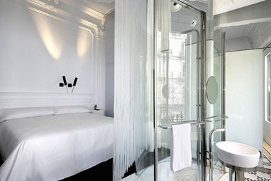 Modelo de dormitorio principal moderno de tamaño medio sin chimenea con paredes blancas