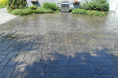 Photo of a large backyard patio in Other with stamped concrete.
