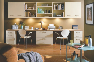 Foto de despacho tradicional renovado grande sin chimenea con paredes beige, suelo de madera clara y escritorio empotrado