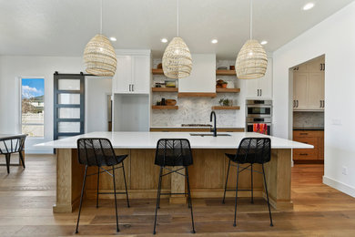 Kitchen pantry - mid-sized transitional single-wall medium tone wood floor kitchen pantry idea in Boise with a single-bowl sink, shaker cabinets, medium tone wood cabinets, quartz countertops, multicolored backsplash, ceramic backsplash, stainless steel appliances, an island and white countertops