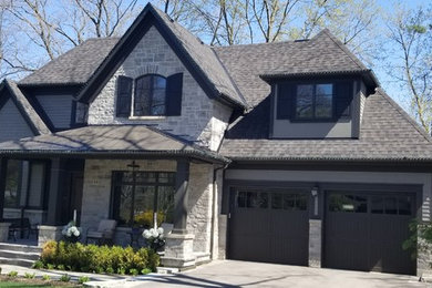 Large transitional gray two-story mixed siding exterior home photo in Toronto with a shingle roof