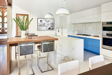 Photo of a large contemporary single-wall open plan kitchen in Charlotte with an undermount sink, flat-panel cabinets, white cabinets, marble benchtops, white splashback, marble splashback, panelled appliances, marble floors, with island, white floor and white benchtop.