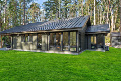 Example of a small trendy gray one-story concrete fiberboard and clapboard exterior home design in Seattle with a metal roof and a gray roof