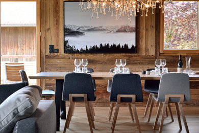 Imagen de comedor contemporáneo grande con suelo de madera clara, madera y vigas vistas