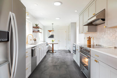 Inspiration for a large modern galley porcelain tile and black floor enclosed kitchen remodel in Seattle with an undermount sink, shaker cabinets, gray cabinets, quartz countertops, white backsplash, porcelain backsplash, stainless steel appliances, no island and white countertops