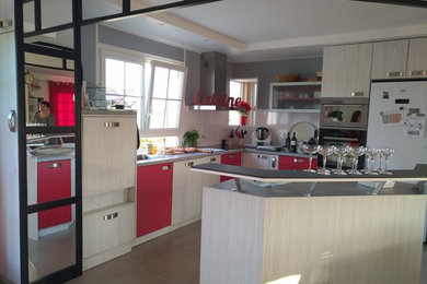 Aménagement d'une grande cuisine ouverte encastrable moderne en L avec un placard à porte affleurante, des portes de placard blanches, un plan de travail en stratifié, une crédence grise, un sol en carrelage de céramique, îlot, un sol gris et un plan de travail gris.
