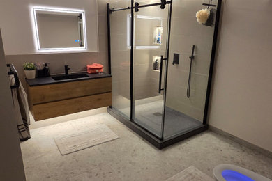 Inspiration for a mid-sized modern master beige tile and ceramic tile ceramic tile, beige floor, single-sink, coffered ceiling and wall paneling bathroom remodel in Montreal with flat-panel cabinets, light wood cabinets, a bidet, beige walls, a wall-mount sink, quartz countertops, black countertops, a niche and a floating vanity