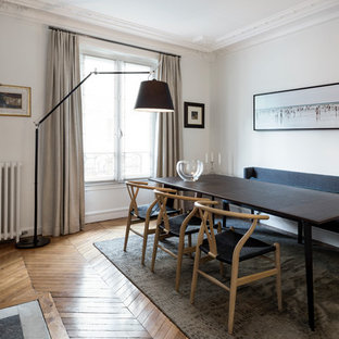 Aménagement d'une salle à manger contemporaine fermée avec un mur blanc, un sol en bois clair, une cheminée standard, un manteau de cheminée en pierre et un sol beige.