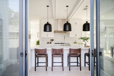 Inspiration for a mid-sized modern galley light wood floor, brown floor and exposed beam eat-in kitchen remodel in San Francisco with a drop-in sink, shaker cabinets, white cabinets, marble countertops, white backsplash, matchstick tile backsplash, stainless steel appliances, an island and gray countertops
