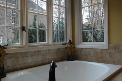 Large trendy master beige tile and ceramic tile ceramic tile bathroom photo in Charlotte with raised-panel cabinets, dark wood cabinets, a drop-in sink, yellow walls and granite countertops